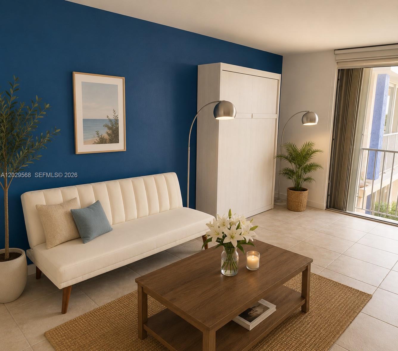 A living room features a blue accent wall, white sofa, coffee table, and a Murphy bed — 800 West Ave # 715, Miami Beach FL 33139, MIAMI BEACH, FL