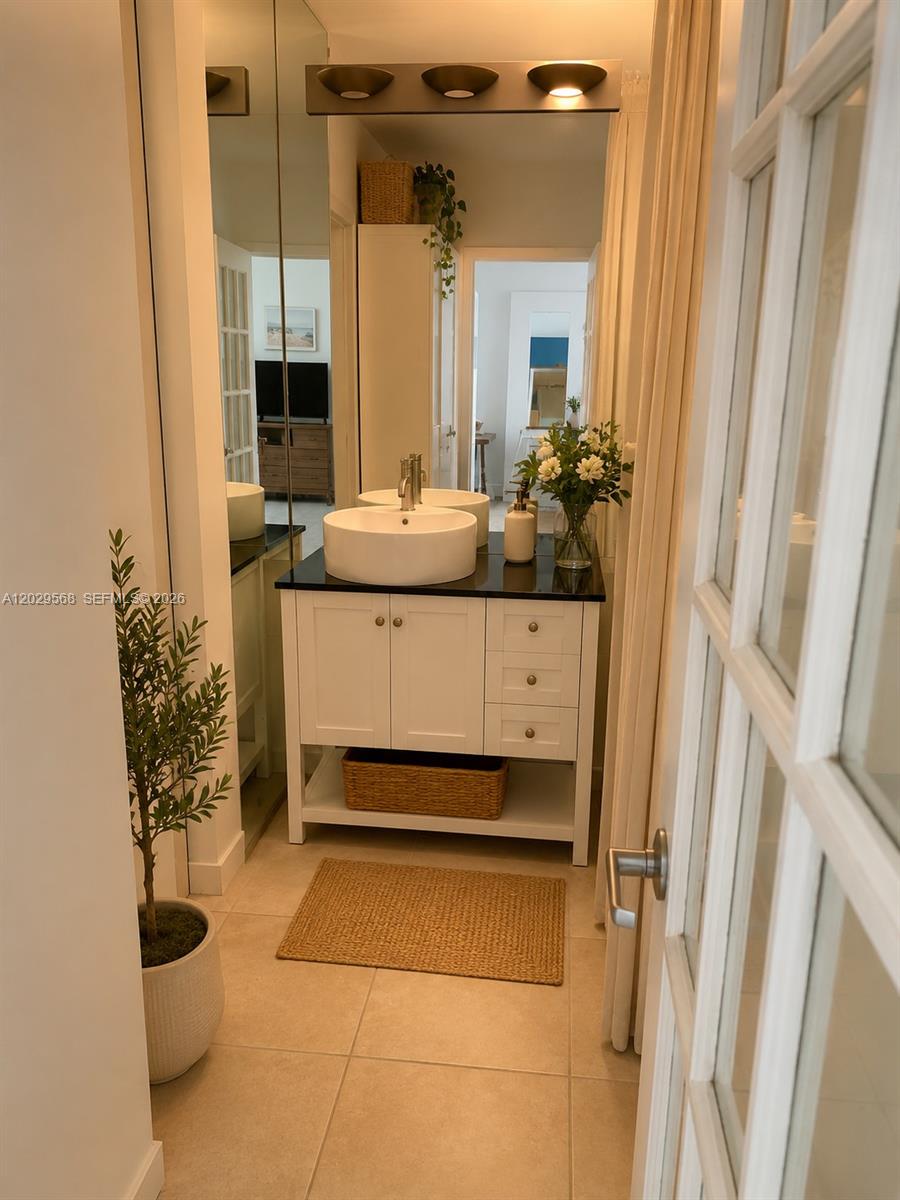 A bathroom features a white vanity with a vessel sink, black countertop, and mirror — 800 West Ave # 715, Miami Beach FL 33139, MIAMI BEACH, FL