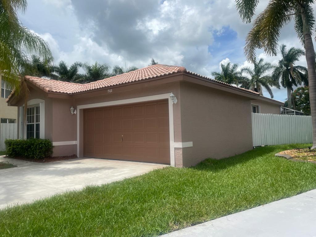 A single-story house with a brown garage door and tile roof sits between two neighbors — 1968 SW 177th Avenue, Miramar FL 33029, MIRAMAR, FL