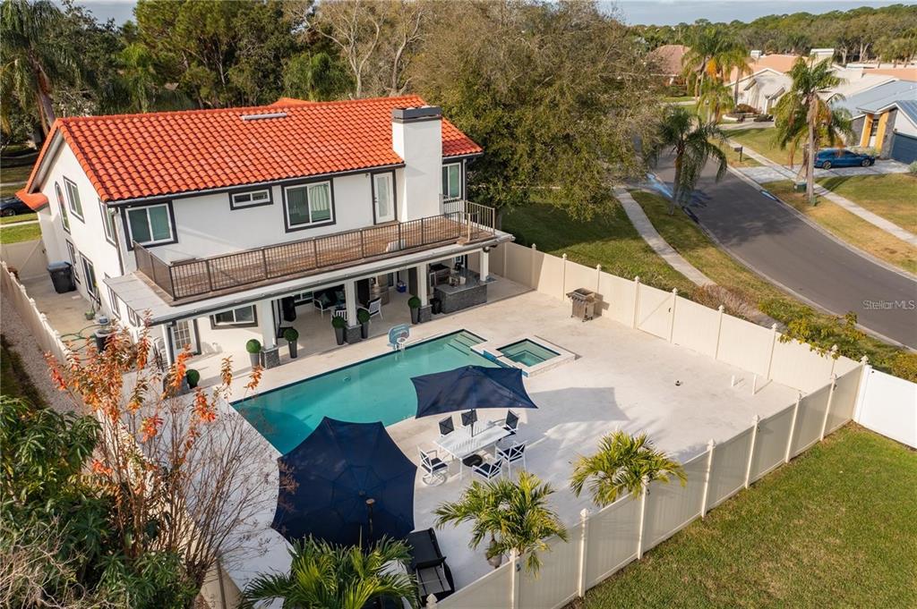 An aerial view of a two-story house with a backyard pool, patio, and privacy fence — 4123 CROSSWATER DRIVE, TAMPA, FL