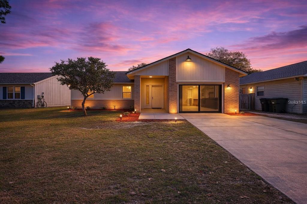 A single-story house with a brick facade, a concrete driveway, and a sunset sky — 2843 CALICO COURT, ORLANDO, FL