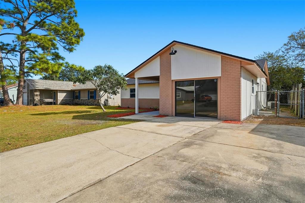 A single-story house features a brick facade, a concrete driveway, and a sliding glass door — 2843 CALICO COURT, ORLANDO, FL