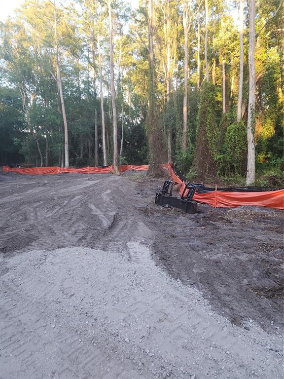 A cleared construction site features orange silt fencing and a piece of heavy equipment — 7709 WINDWARD WAY, ODESSA, FL
