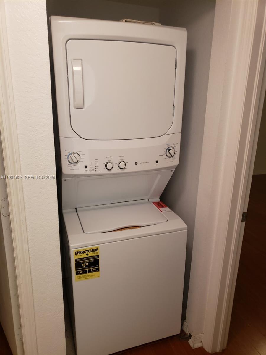 A white stacked washer and dryer unit is installed in a small closet — 36 NW 6th Ave # 906, Miami FL 33128, MIAMI, FL