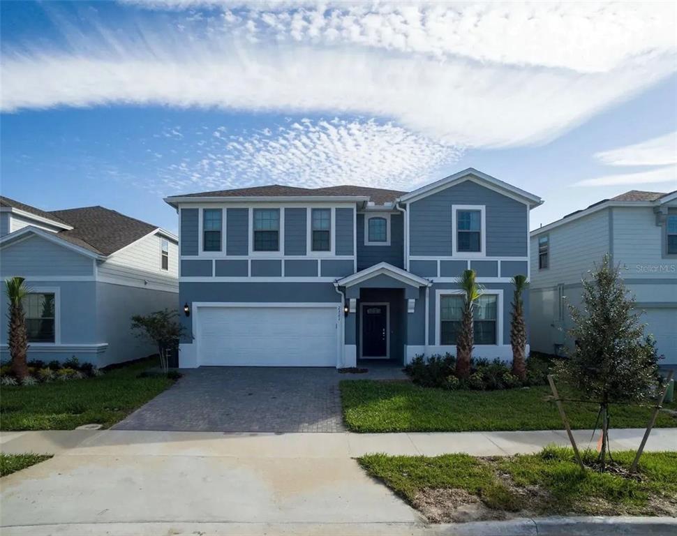 A two-story blue house with a white garage and a paved driveway — 2321 LUXOR DRIVE, KISSIMMEE, FL