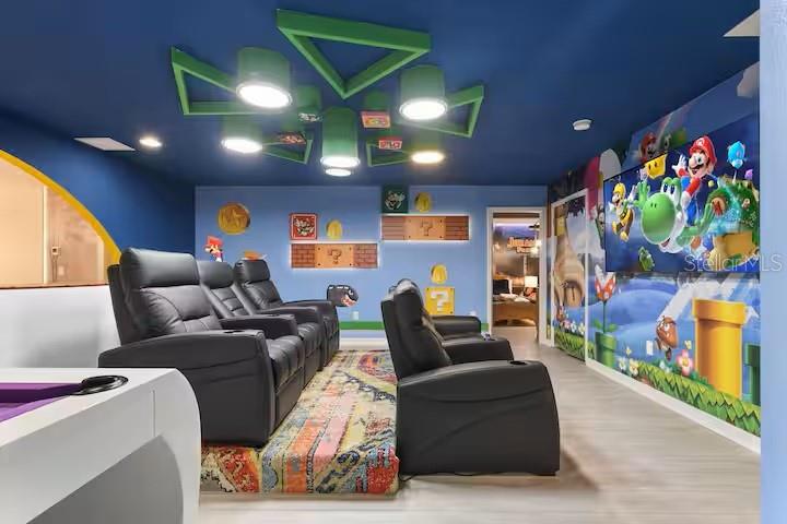 A themed home theater features black leather recliners, a large television, and Super Mario decor — 2321 LUXOR DRIVE, KISSIMMEE, FL