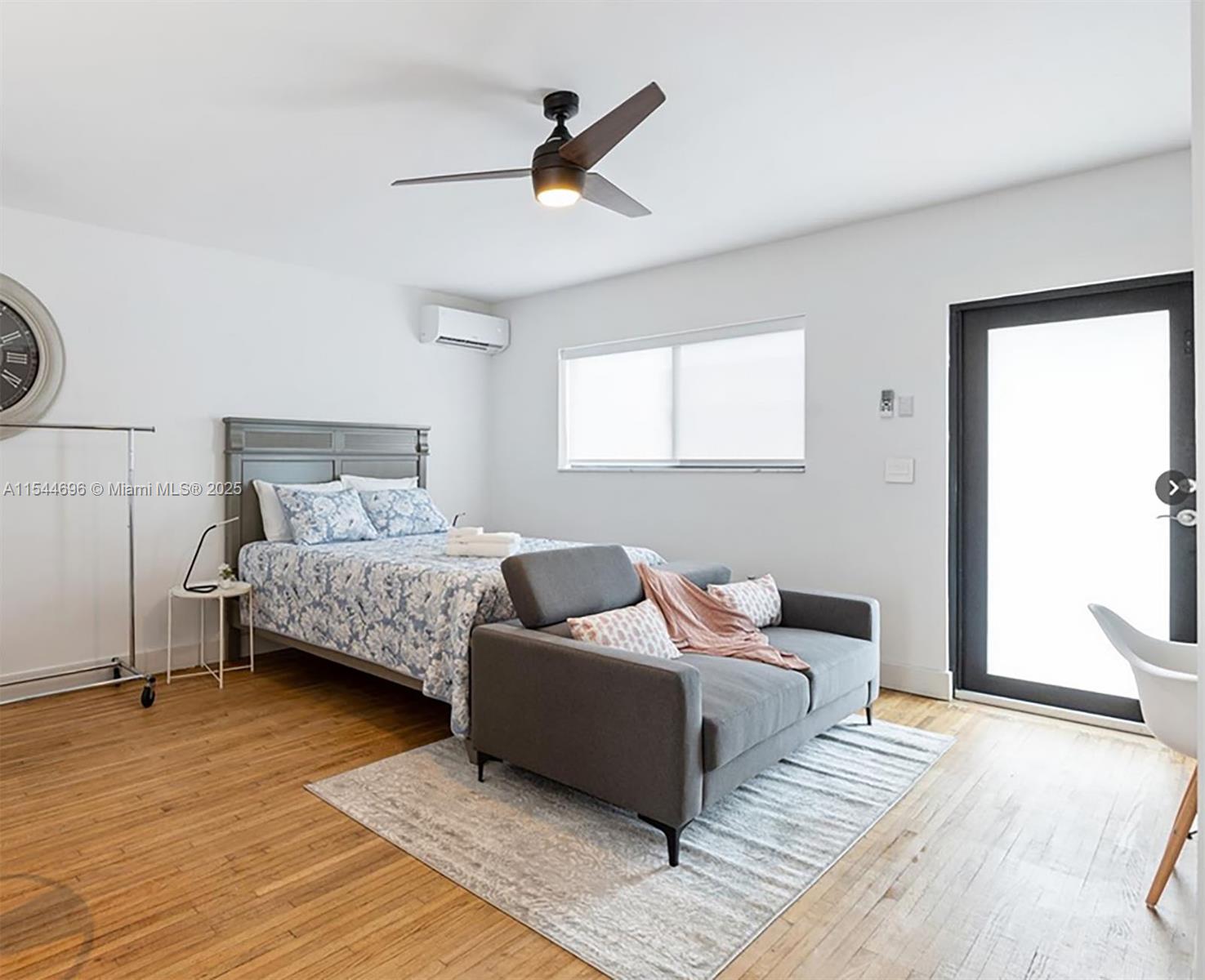 A bedroom features a bed, a gray sofa, a ceiling fan, and hardwood flooring — 740 SW 9th St # 2, Miami FL 33130, MIAMI, FL