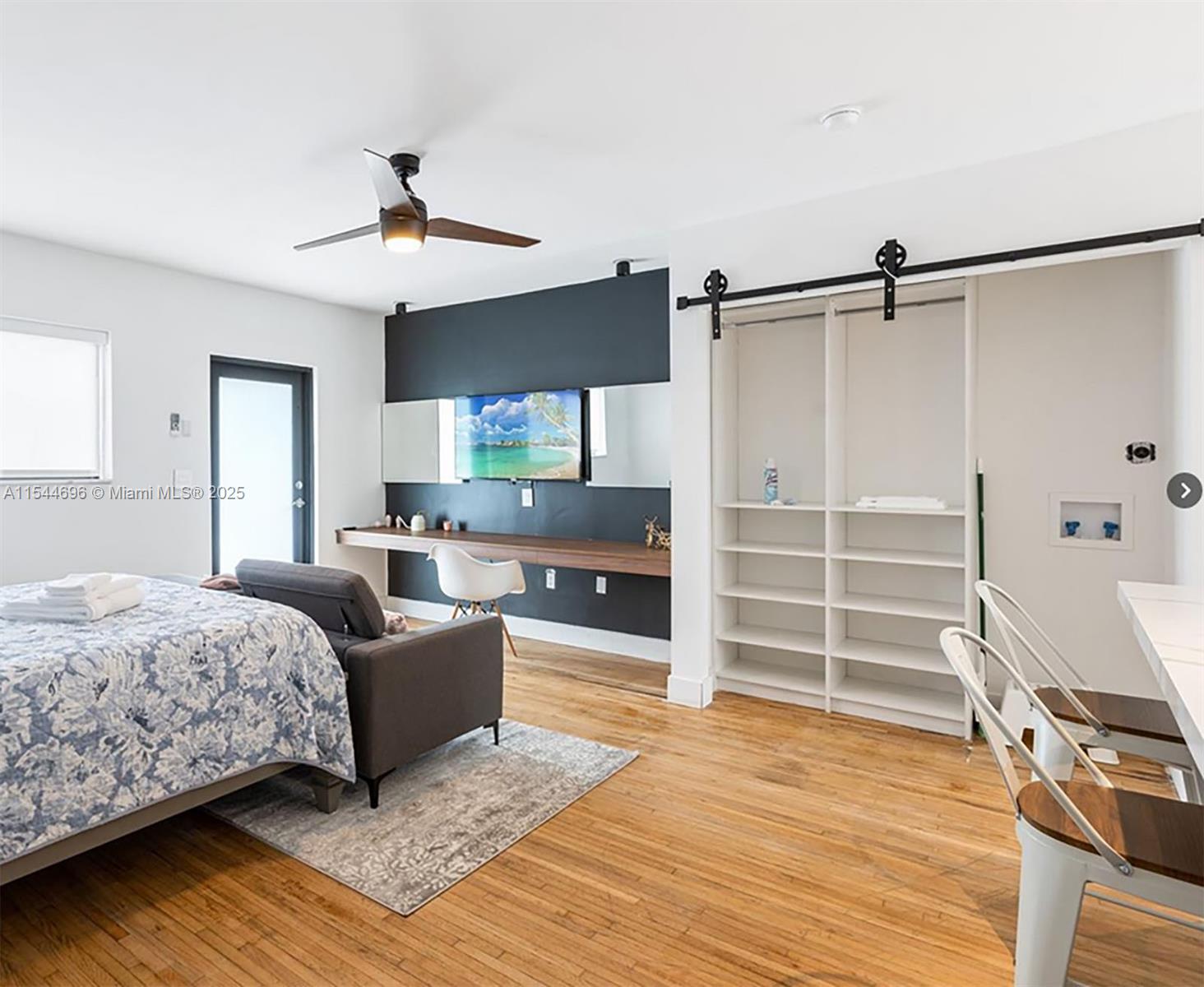 A studio apartment features a bed, a desk with a television, and open shelving — 740 SW 9th St # 2, Miami FL 33130, MIAMI, FL