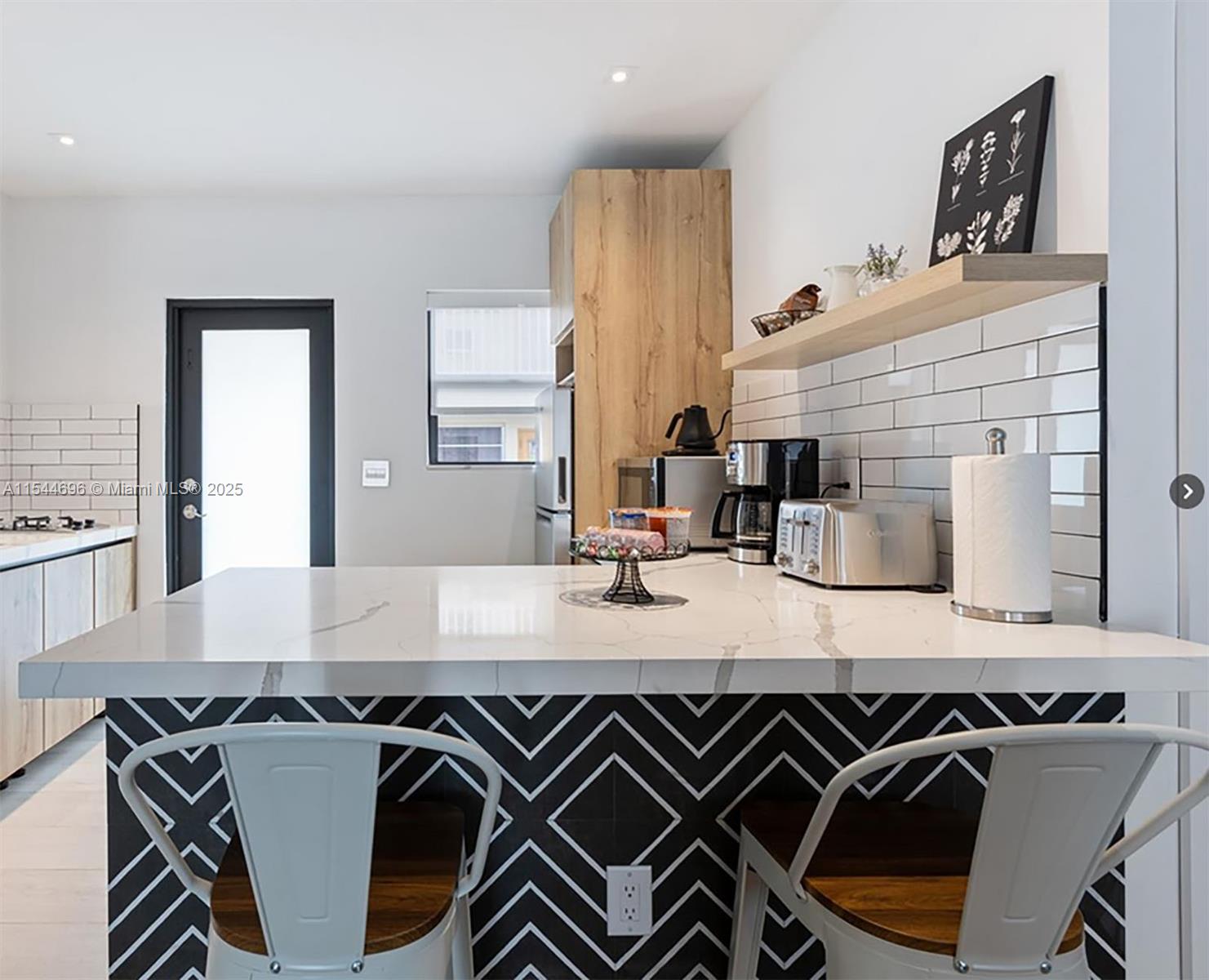 A kitchen island with a geometric tile base and marble countertop sits before two metal stools — 740 SW 9th St # 2, Miami FL 33130, MIAMI, FL