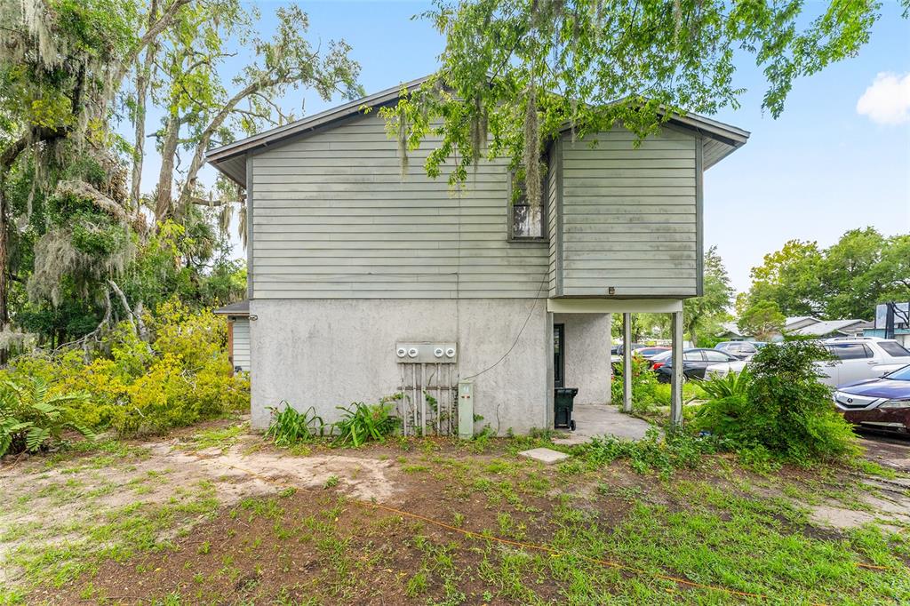 The exterior of a two-story house features gray horizontal siding above a stucco base — 803 SW 2ND TERRACE, GAINESVILLE, FL