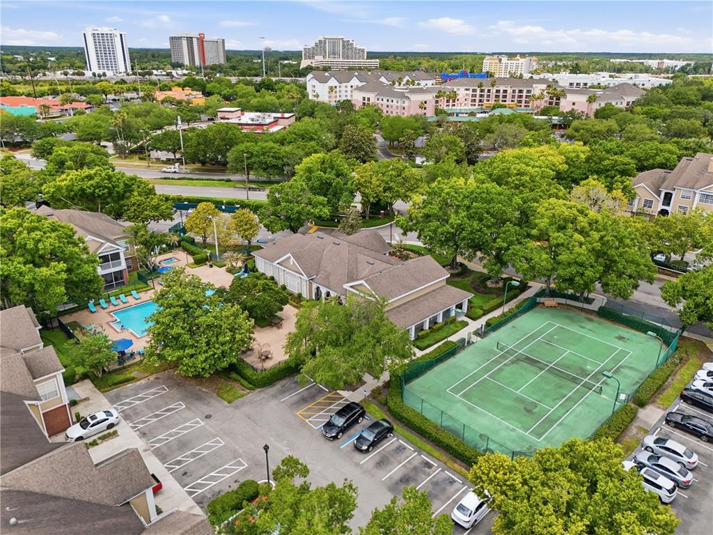 An aerial view shows a residential complex with a swimming pool, tennis court, and parking — 13001 MULBERRY PARK DRIVE UNIT 132, ORLANDO, FL