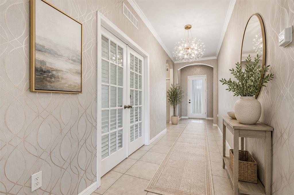 A living room features a slatted wood accent wall, a sectional sofa, and tile flooring — 1494 CHELSEA MANOR CIRCLE, DELAND, FL