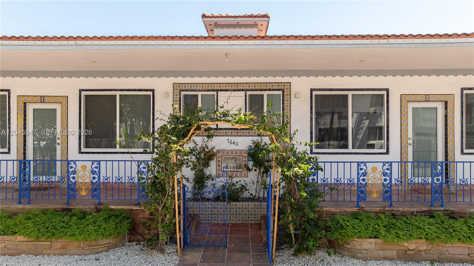 The exterior of a single-story building features a blue metal railing and tiled accents — 7640 Harding Ave, Miami Beach FL 33141, MIAMI BEACH, FL