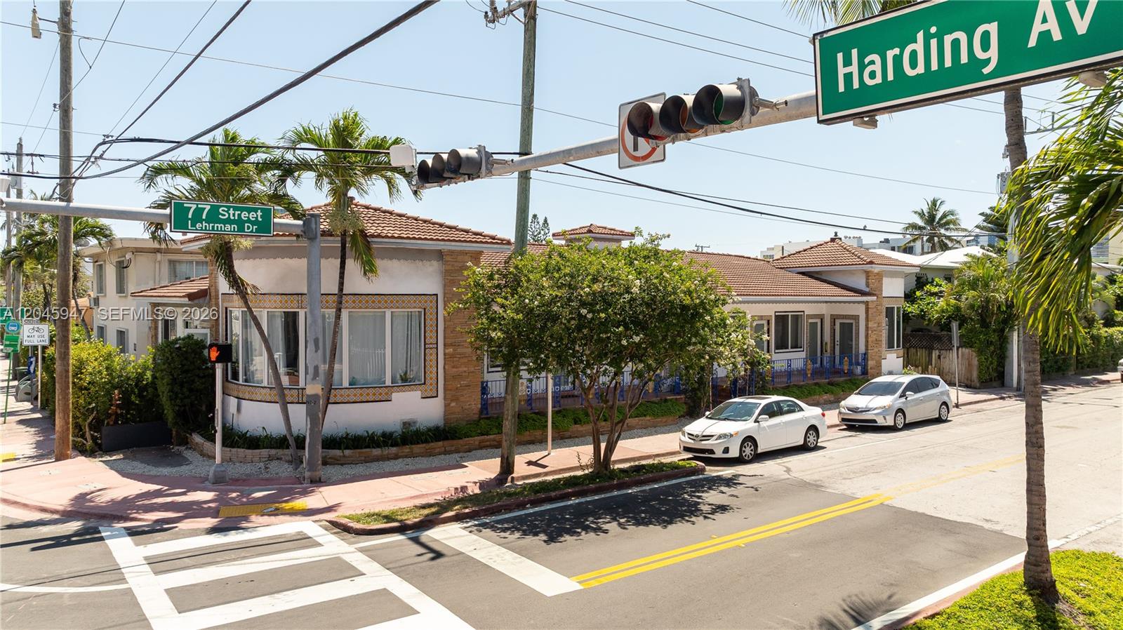 A corner building with a tiled roof and decorative exterior trim sits at a street intersection — 7640 Harding Ave, Miami Beach FL 33141, MIAMI BEACH, FL