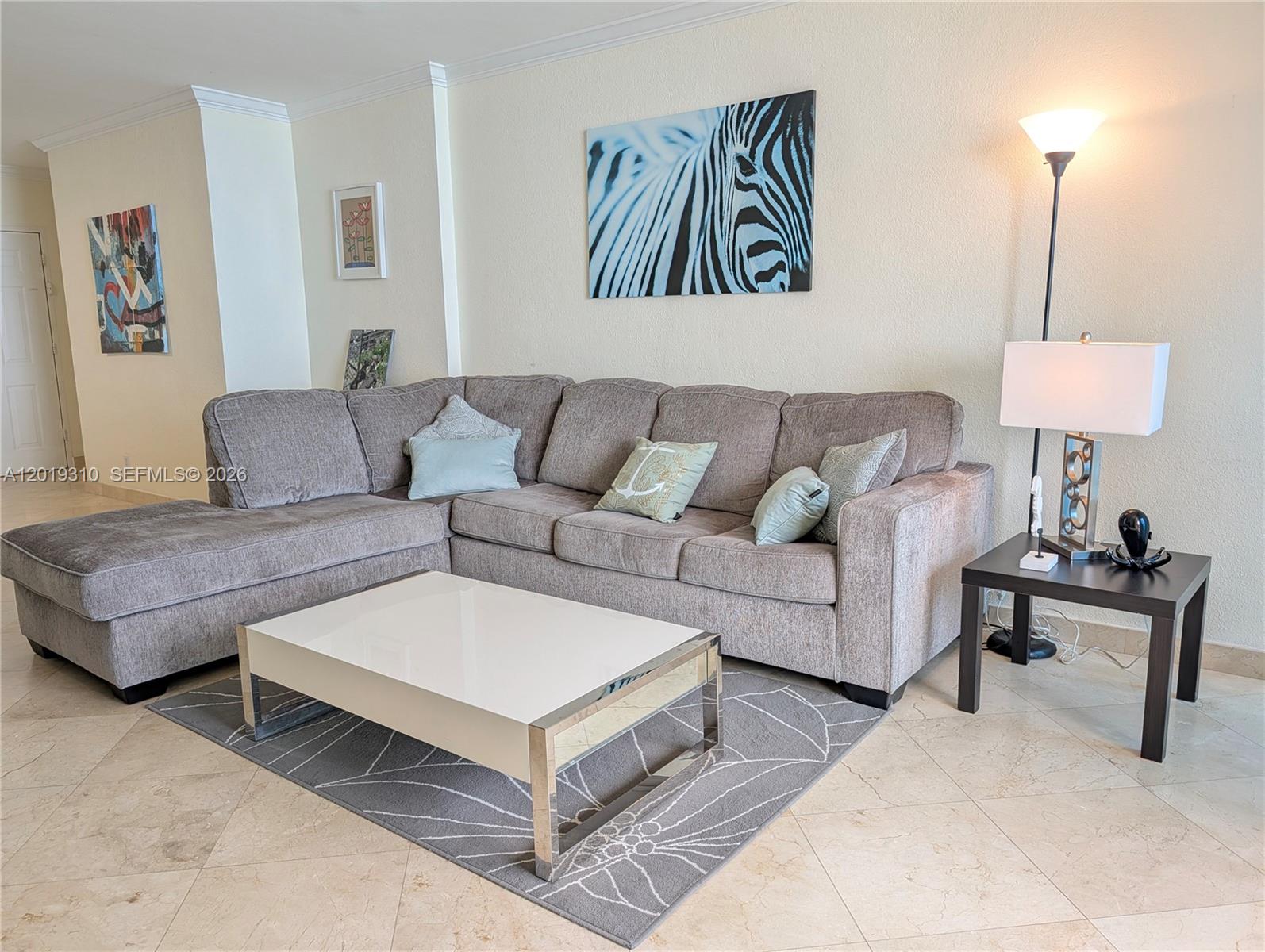 A living room features a grey sectional sofa, a white coffee table, and wall art — 2501 S Ocean Dr # 1021, Hollywood FL 33019, HOLLYWOOD, FL