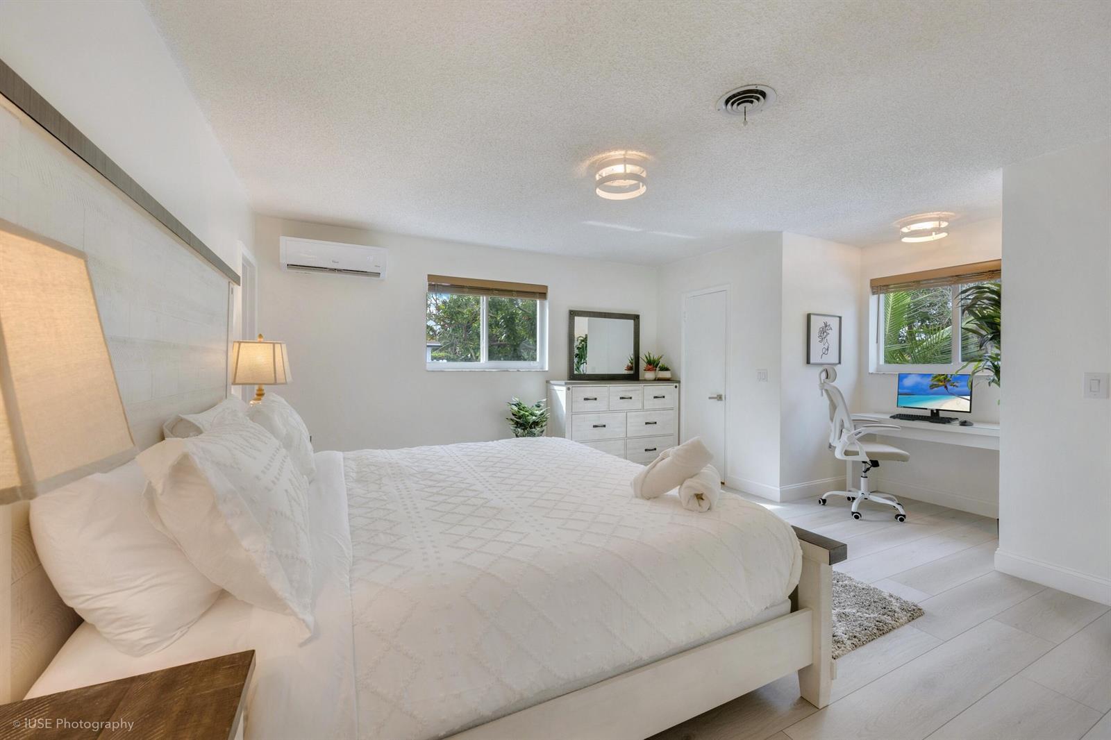 A bright bedroom features a white bed, a dresser, and a built-in desk area — 1250 Arthur Street, Hollywood FL 33019, HOLLYWOOD, FL