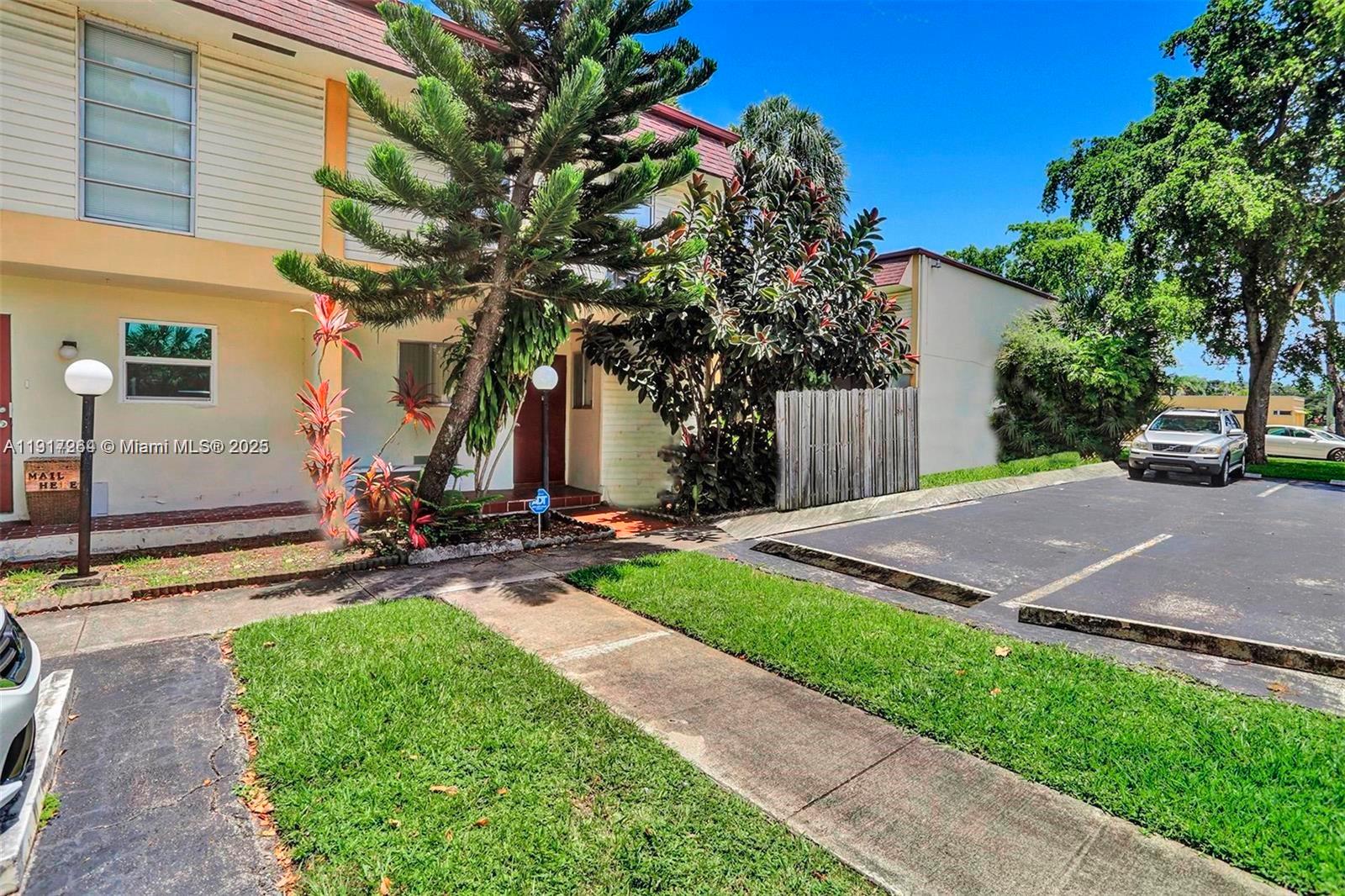 A two-story townhouse exterior features a front walkway, landscaping, and an adjacent parking lot — 2701 N 34th Ave # 1D, Hollywood FL 33021, HOLLYWOOD, FL