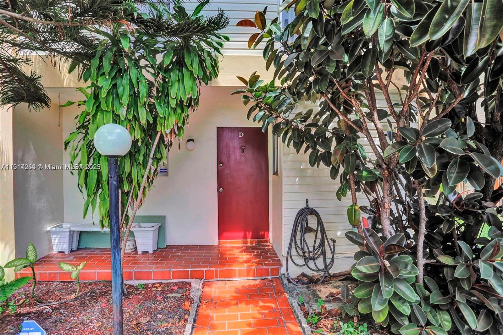 A red front door labeled D is accessed by a brick walkway and porch — 2701 N 34th Ave # 1D, Hollywood FL 33021, HOLLYWOOD, FL