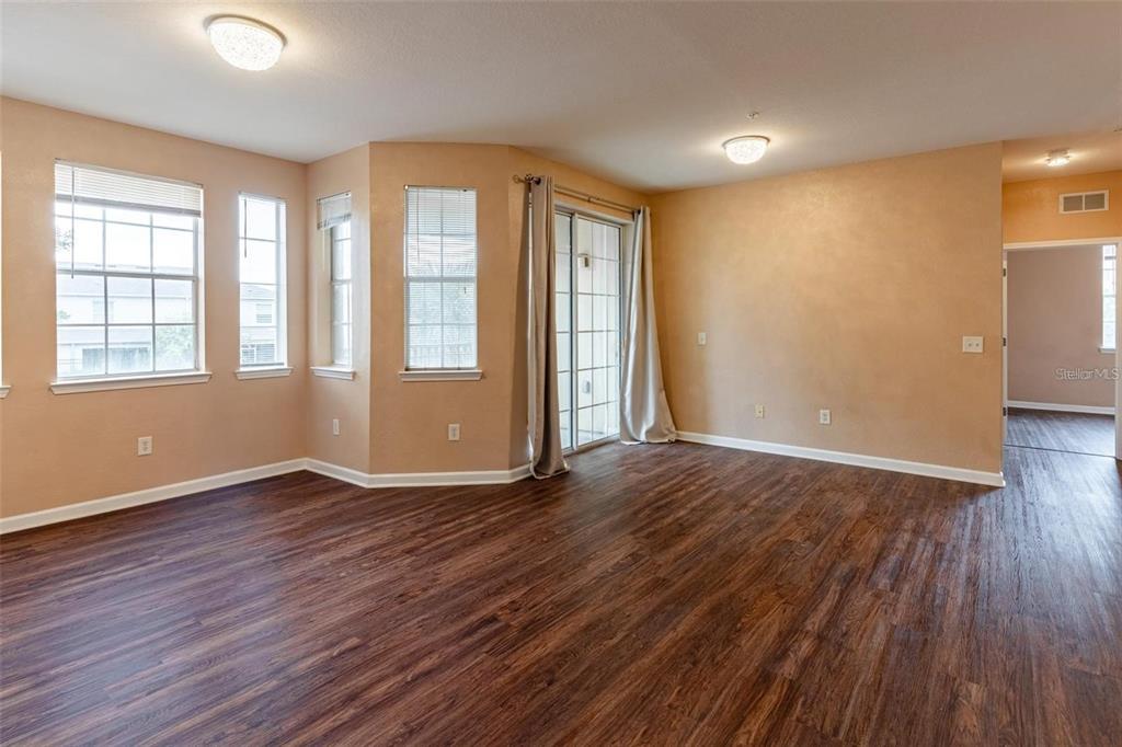 A living room features wood-look flooring, a gray sofa, a coffee table, and large windows — 709 TERRACE RIDGE CIRCLE UNIT 709, DAVENPORT, FL