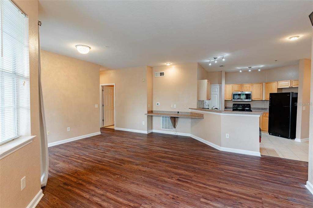 A living room with wood floors, a sectional sofa, a dining area, and a kitchen — 709 TERRACE RIDGE CIRCLE UNIT 709, DAVENPORT, FL