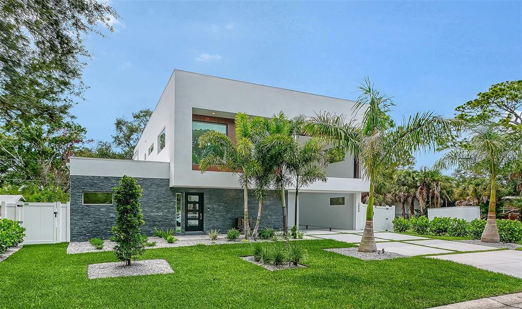 A modern two-story house features a stone-clad facade, large windows, and a landscaped front yard — 2050 EUCLID TERRACE, SARASOTA, FL