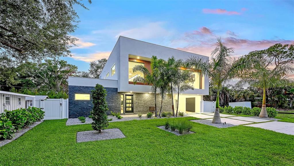 An aerial view shows a modern white house surrounded by dense trees in a neighborhood — 2050 EUCLID TERRACE, SARASOTA, FL