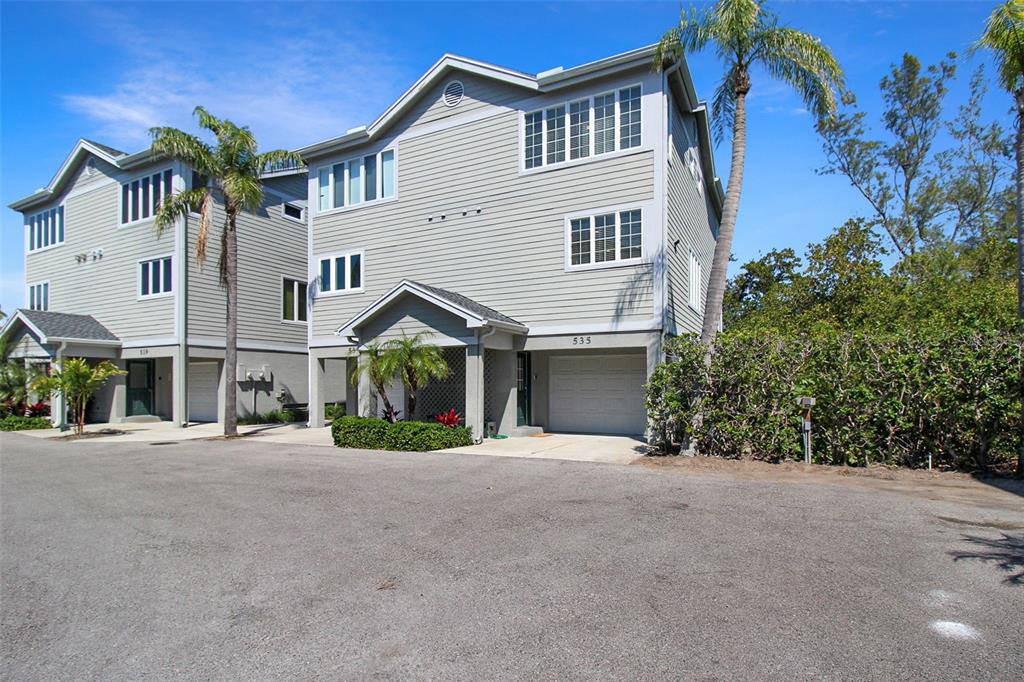 A two-story gray siding townhouse with a garage and palm trees in front — 535 FOREST WAY, LONGBOAT KEY, FL