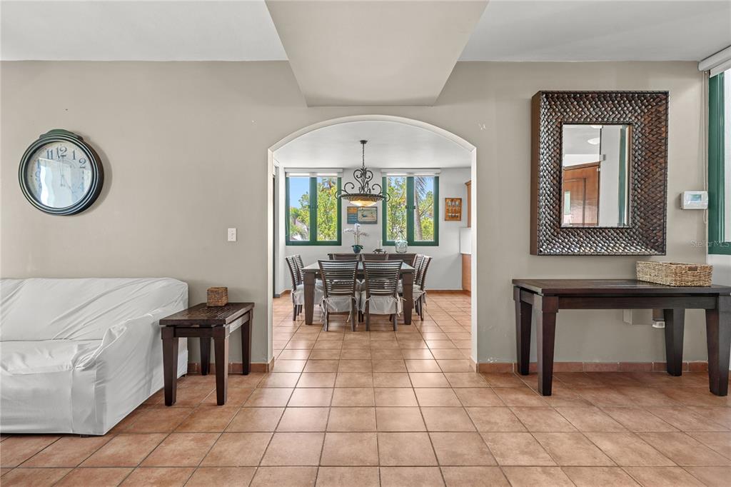 A living room with tile floors leads through an arched doorway to a dining area — 2101 RIO MAR VILLAGE, RIO GRANDE, PR