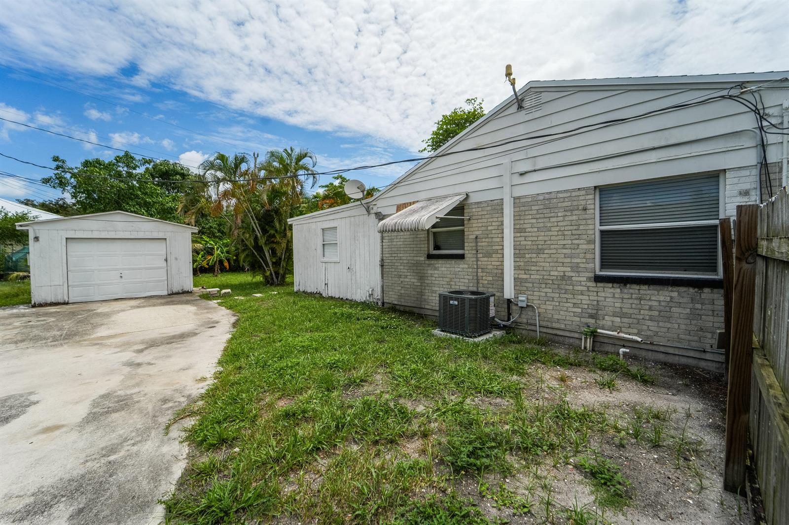 The exterior view shows a brick house, a detached garage, and a grassy yard — 1007 Charles Street, West Palm Beach FL 33401, WEST PALM BEACH, FL