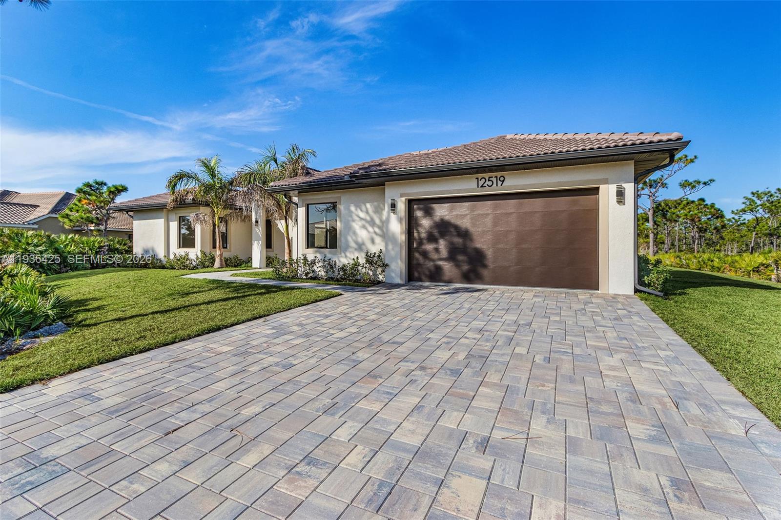 A single-story house with a paved driveway, a two-car garage, and palm trees — OTHER CITY - IN THE STATE OF FLORIDA, FL