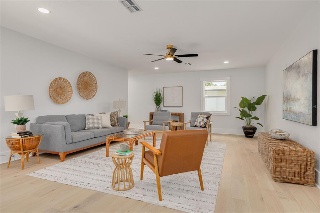 A living room features a gray sofa, a brown armchair, and light wood flooring — 2528 4TH AVENUE S, ST PETERSBURG, FL