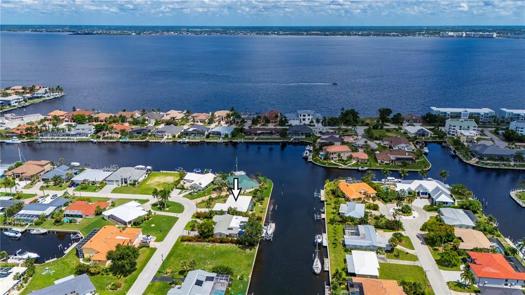 An aerial view shows a waterfront house with a boat dock on a canal — 110 GULFVIEW ROAD, PUNTA GORDA, FL