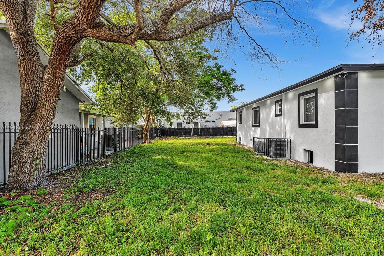 A bright, empty room features white walls, marble-patterned tile flooring, and a window with blinds — 5850 NE 3rd Ave, Miami FL 33137, MIAMI, FL