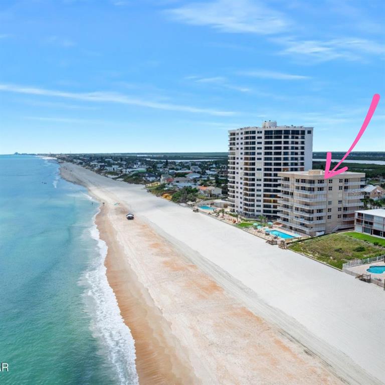 An exterior view of a multi-story beachfront condominium building with a swimming pool and balconies — 3851 S ATLANTIC AVENUE UNIT 701, DAYTONA BEACH, FL