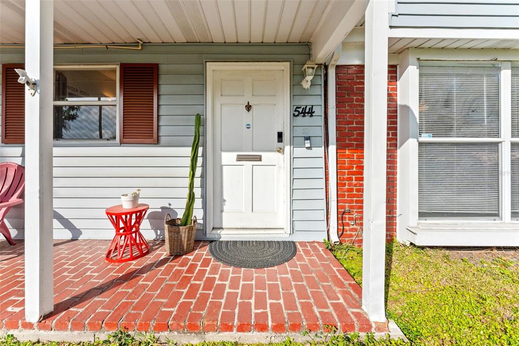 A front porch features a red brick floor, a white door, and a tall potted cactus — 544 SEVERN AVENUE, TAMPA, FL