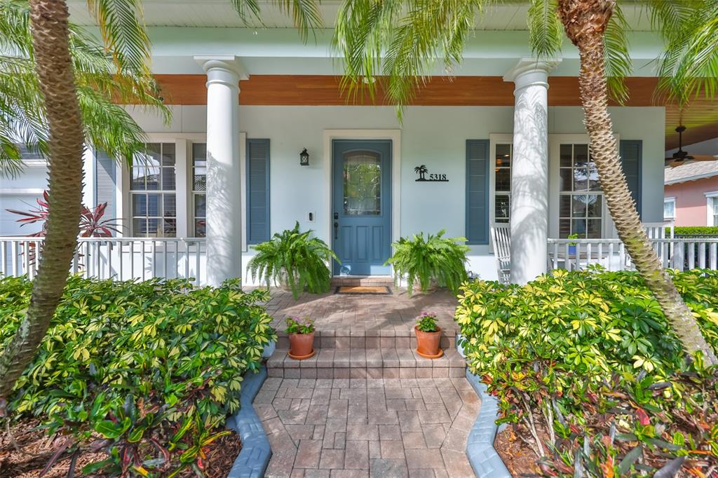 A two-story light blue house with a front porch and palm trees in the yard — 5318 LOON NEST COURT, APOLLO BEACH, FL