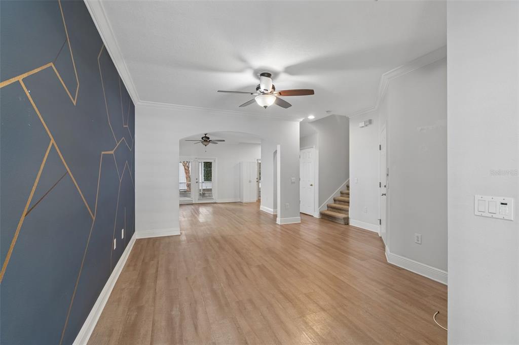 An interior view shows a living area with wood-look flooring and a blue accent wall — 3125 SANTORINI COURT, TAMPA, FL