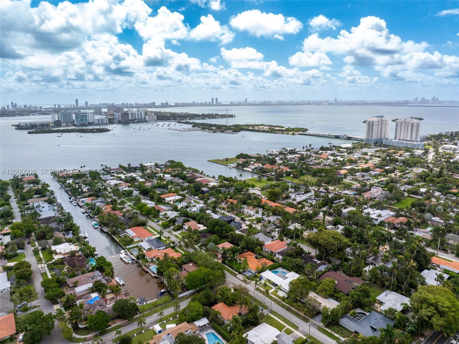 An aerial view shows a residential neighborhood with a canal leading to a large bay — 1104 NE 85th St, Miami FL 33138, MIAMI, FL