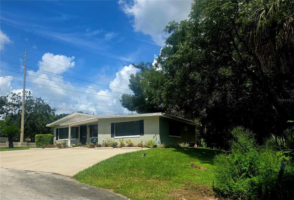 A single-story house with a light-colored exterior and a concrete driveway sits on a grassy lot — 498 ESTHER LANE, ALTAMONTE SPRINGS, FL