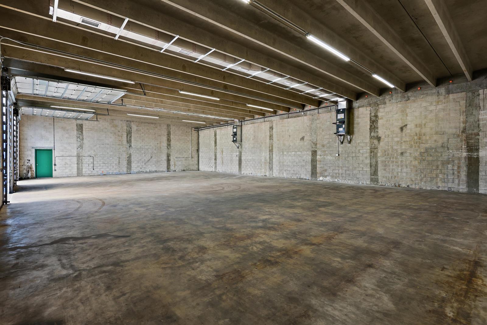 An empty industrial warehouse space with concrete block walls, a concrete floor, and exposed beams — 2605 Kelly Lane, FL 33460, FL