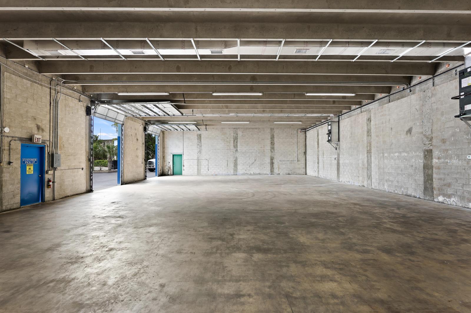 An empty industrial warehouse space features concrete walls, a polished floor, and overhead lighting — 2605 Kelly Lane, FL 33460, FL