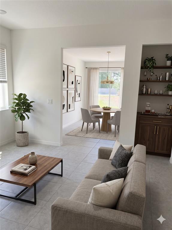 This living room features tile floors, a wooden coffee table, and an adjacent dining area — 34224 ROGALLO LANE, WESLEY CHAPEL, FL