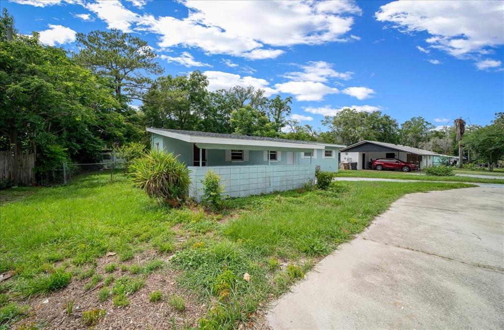 A light blue single-story house with a concrete block privacy wall and a concrete driveway — 1214 SE 36TH AVENUE, OCALA, FL