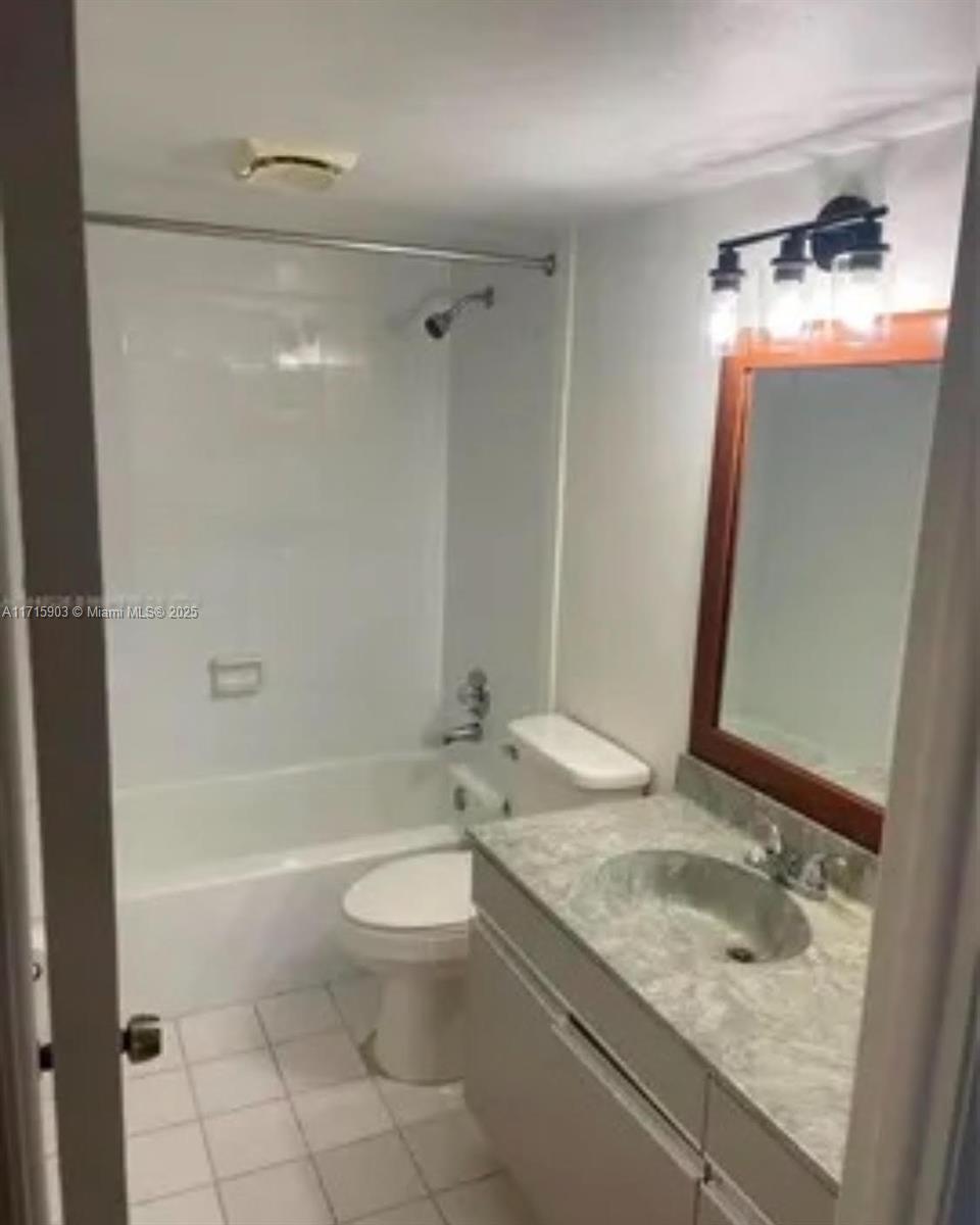 A bathroom features a white tub-shower combo, a vanity with a stone countertop, and mirror — 6700 Cypress Rd # 512, Plantation FL 33317, PLANTATION, FL