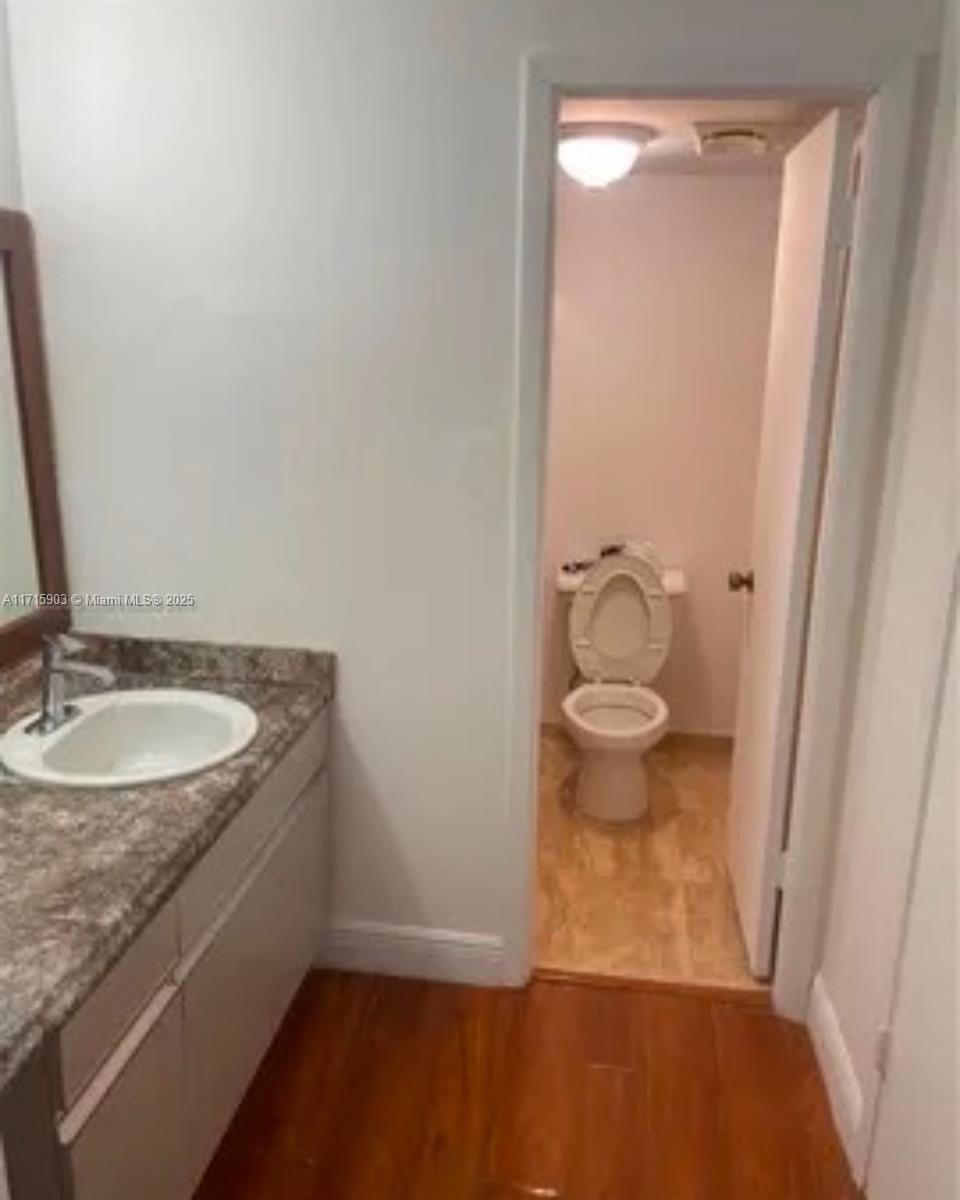 A bathroom features a vanity with a stone countertop and an adjacent toilet room — 6700 Cypress Rd # 512, Plantation FL 33317, PLANTATION, FL