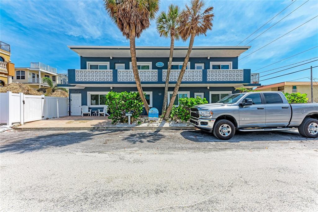 A two-story blue apartment building with palm trees and a parked pickup truck in front — 101 25TH STREET N UNIT 3, BRADENTON BEACH, FL