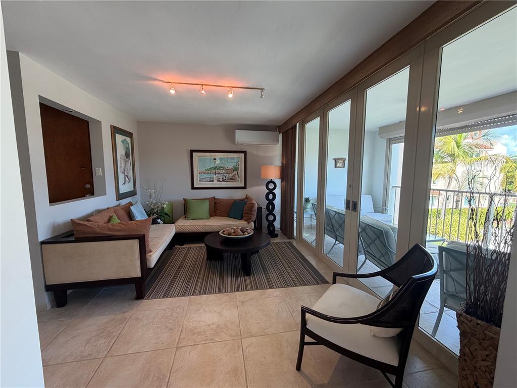 A living room features tile floors, two sofas, a coffee table, and sliding glass doors — Apt B-205 COND. HARBOUR POINTS, HUMACAO, PR
