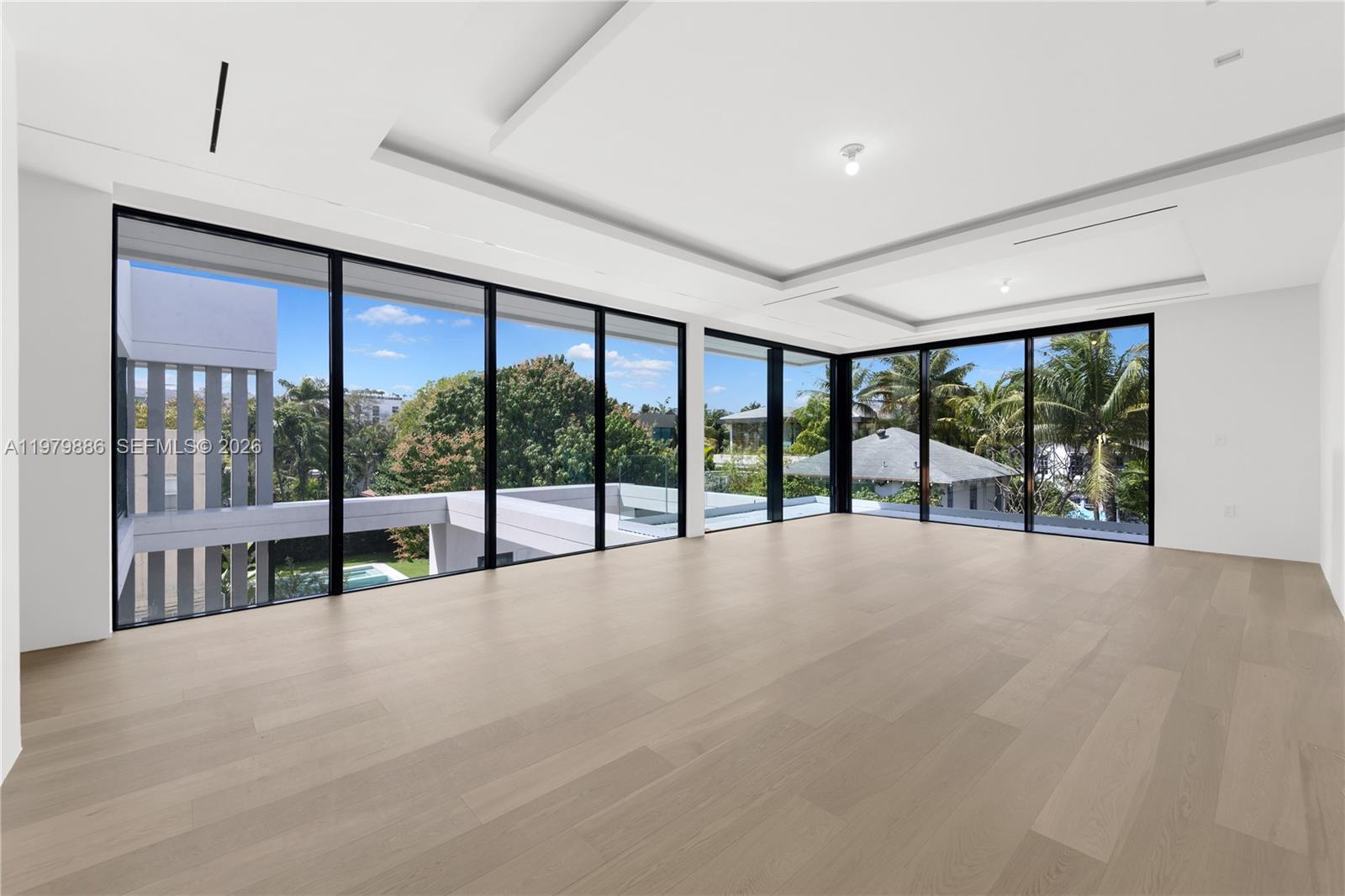 A bright, empty room features light wood floors, white walls, and floor-to-ceiling glass windows — 2094 Prairie Ave, Miami Beach FL 33139, MIAMI BEACH, FL