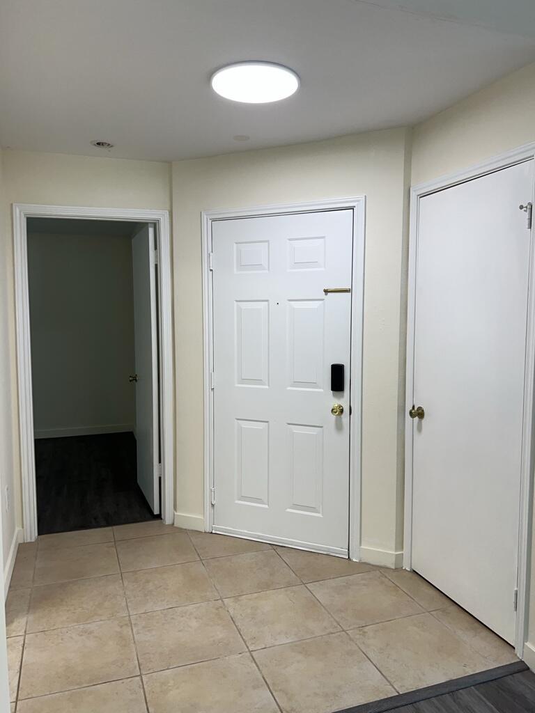 An entryway features beige tile flooring, a white front door, and two interior doors — 2350 NW 33rd Street # 807, Oakland Park FL 33309, OAKLAND PARK, FL