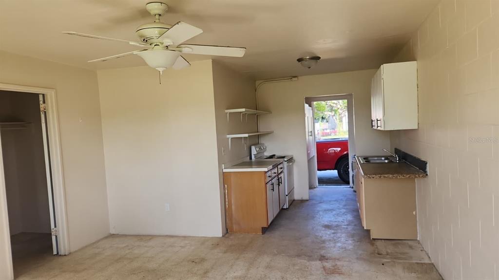 A kitchen with wood cabinets, a ceiling fan, and an exterior door leading outside — 2222 W SOUTH STREET UNIT 2203, ORLANDO, FL